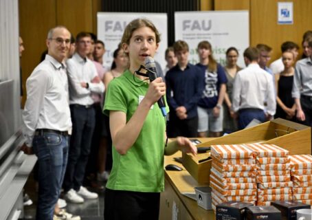 Dr. Alison Mitchell vom Erlangen Centre for Astroparticle Physics hielt die Laudatio Physik. Im Hintergrund sind links Prof. Dr. Julien Bachmann (FAU) und die Teilnehmenden der Physik zu sehen. (Foto: Harald Sippel / FAU)